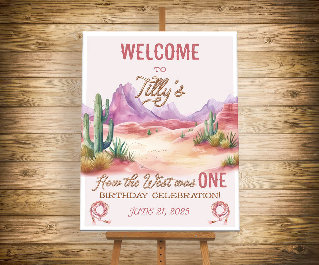 How the west was ONE cowgirl birthday welcome sign with pink desert landscape.