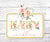 Printable Baby in Bloom floral cake topper on white wood background, showcasing pink watercolor flowers and faux gold lettering.
