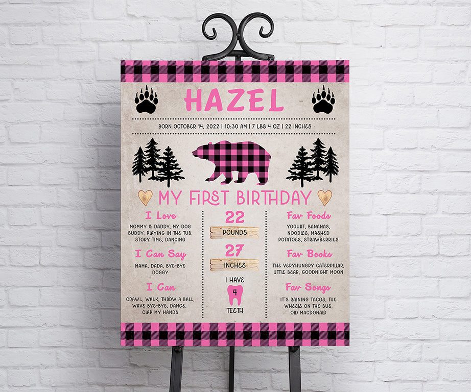 Pink plaid wild one first birthday milestone sign with rustic woodland graphics.