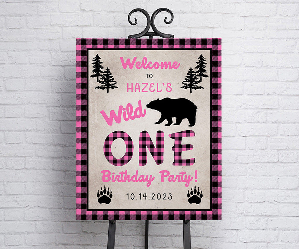 Pink buffalo plaid wild one birthday welcome sign with rustic bear and woodland graphics.