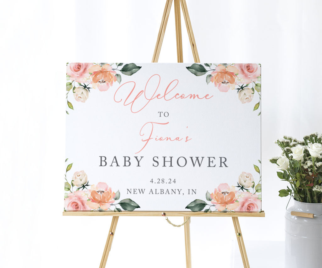 Pink and white floral baby shower welcome sign on easel.