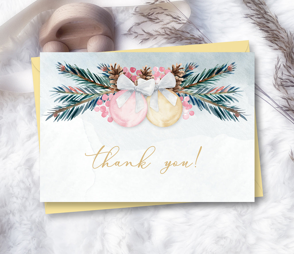 Winter baby shower thank you card with pink and gold ornaments with pine greenery.
