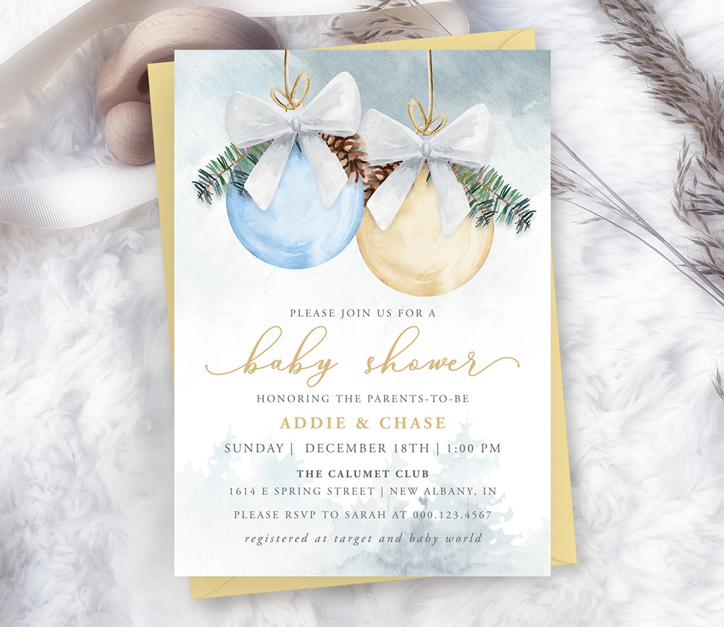 Winter Christmas boy baby shower invitation with blue and gold ornaments and pine greenery.