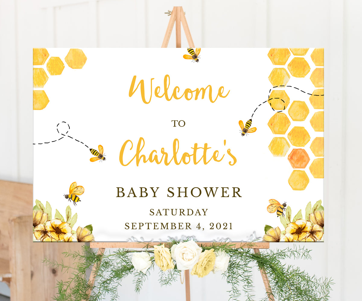 Bee baby shower welcome sign with honeycomb, bees and yellow flower on an easel