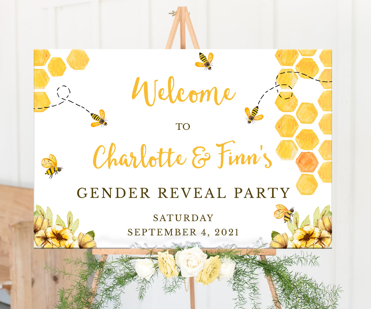 Bee gender reveal welcome sign on easel with honeycomb, buzzing bees and yellow flowers