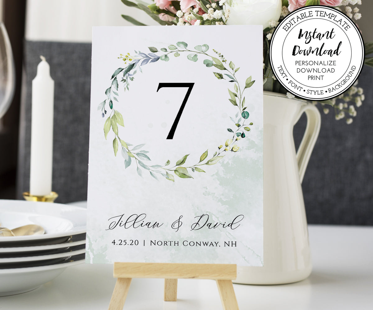 Personalized greenery table number card in wooden holder on reception table